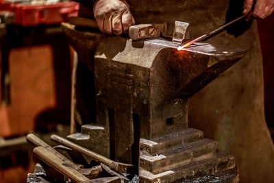 Cropped hands of man working on metal in workshop