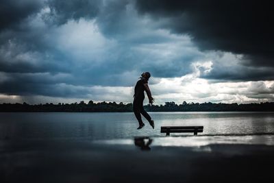 Man standing on lake against sky