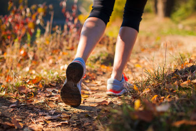 Low section of person running on field