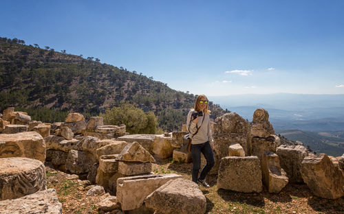 Woman standing by old ruins against sky