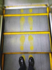 Low section of man standing on metal