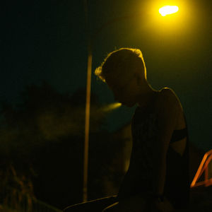 Young woman sitting outdoors at night