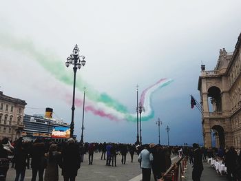 People on street in city against sky