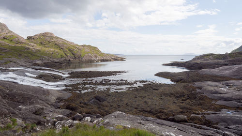 Scenic view of sea and cliff against sky