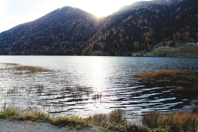 Scenic view of lake by mountain against sky