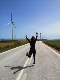 Full length of woman jumping on road