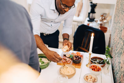 Mature man having food at dining table in party