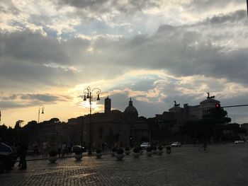 Buildings against cloudy sky at sunset