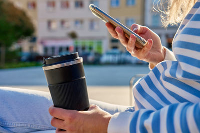 Midsection of woman using mobile phone