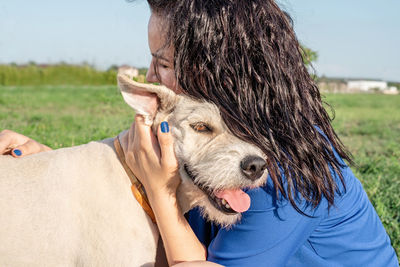 Midsection of a woman with dog on field