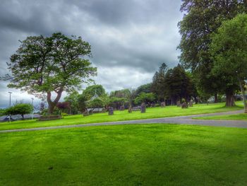 Scenic view of grassy field against cloudy sky