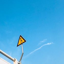 Low angle view of road sign against blue sky