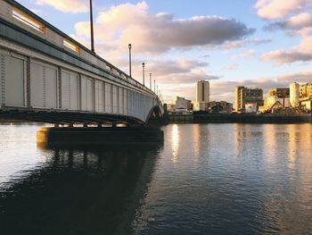 Bridge over river against sky during sunset