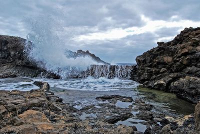 Rocks in sea against sky