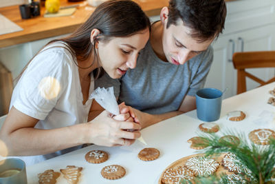 Young couple sitting on table at home