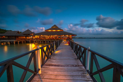 Pier over sea against sky at dusk