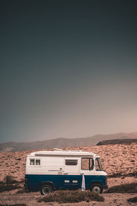 Vintage car on desert against sky