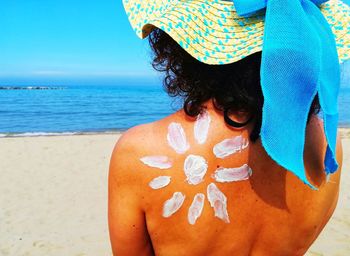 Rear view of woman in hat at beach