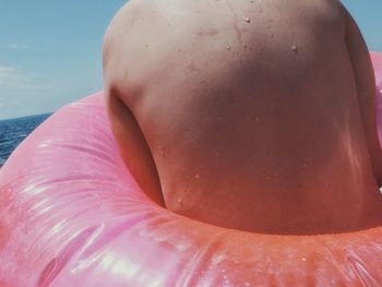 Close-up of shirtless woman in sea