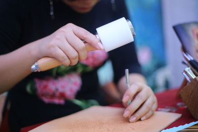 Cropped image of woman making crafts at table