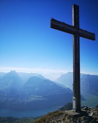 Cross on mountain against clear blue sky