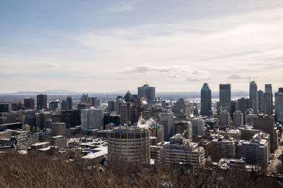 Aerial view of buildings in city against sky