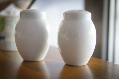 Close-up of salt and pepper shakers on table at home