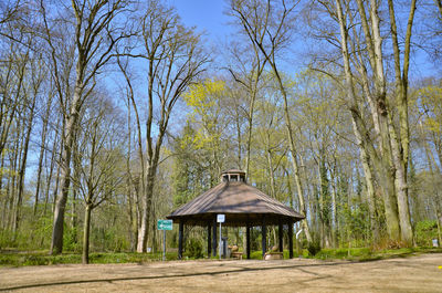 Built structure by trees in forest against sky