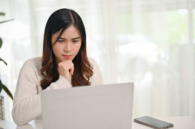 Young woman using laptop at home