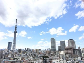 View of cityscape against cloudy sky
