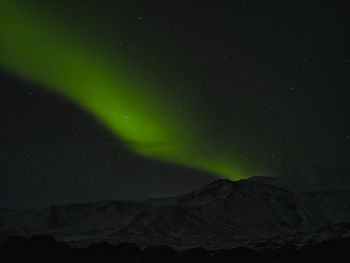 Low angle view of snowcapped mountain against sky at night