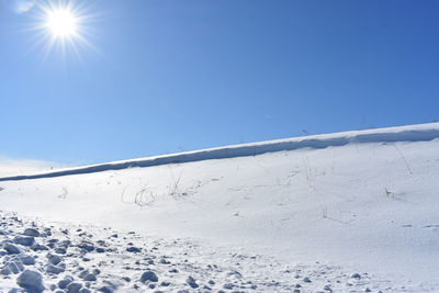 Scenic view of snow covered field against clear blue sky