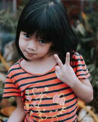 Portrait of cute girl showing peace sign