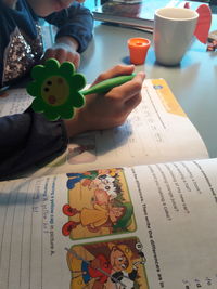 Close-up of boy holding book on table