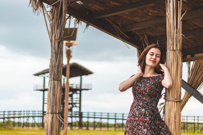 Portrait of young woman standing against built structure