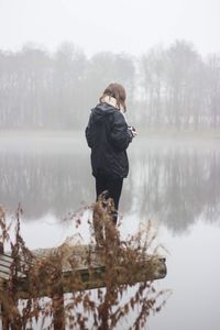 Rear view of woman in lake against sky