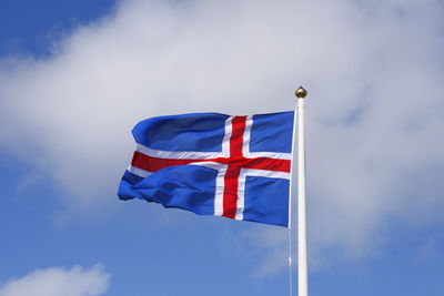 Low angle view of flag against blue sky