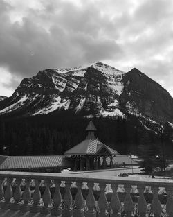 Houses on mountain against cloudy sky