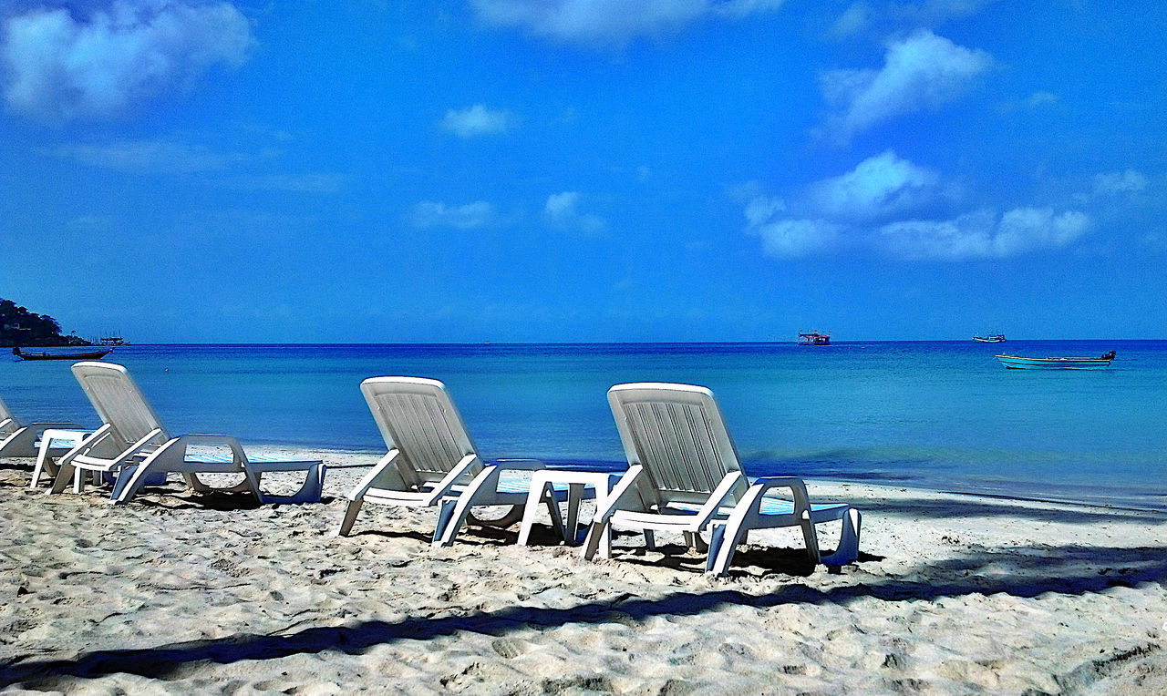 CHAIRS ON BEACH AGAINST SKY