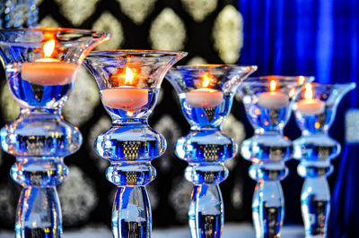 Close-up of lit candles arranged on table