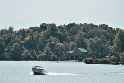 Speedboat in lake ontario in autumn. colourful vivid trees. canada usa.