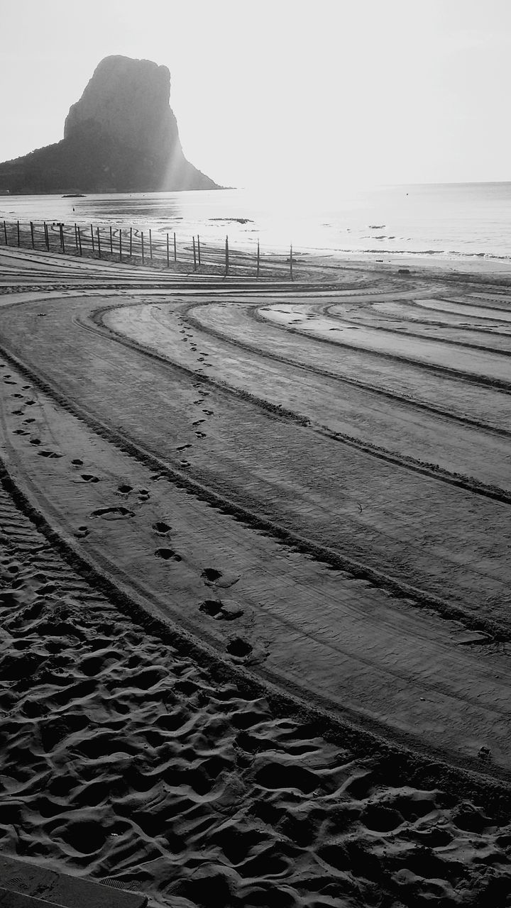 SURFACE LEVEL OF CALM BEACH AGAINST THE SKY