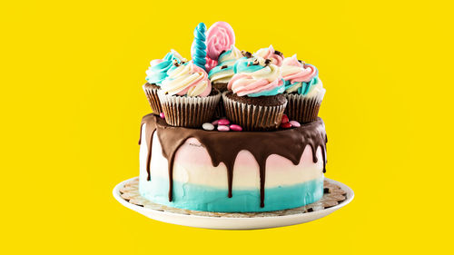 Close-up of cupcakes against yellow background