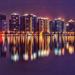 Reflection of illuminated city in water at night