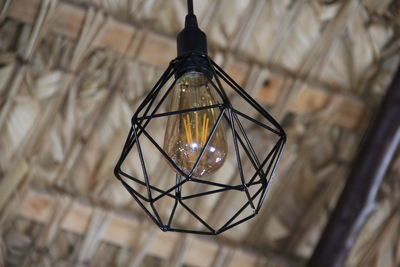 Low angle view of illuminated pendant light hanging on ceiling