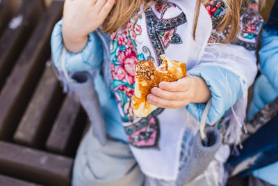 Midsection of girl holding food outdoors