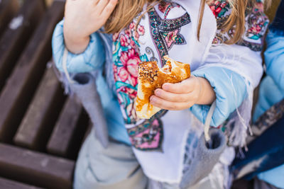 Midsection of woman holding ice cream standing outdoors