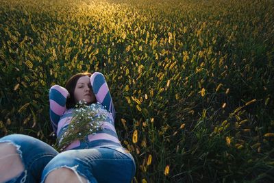 High angle view of woman lying on grassy field