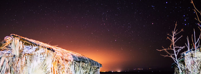 Low angle view of illuminated building against sky at night