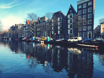 Boats in canal amidst buildings in city